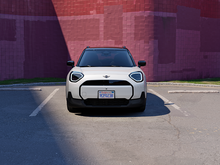 Front view of the all-electric MINI Aceman in Nanuq White and Black Roof parking.