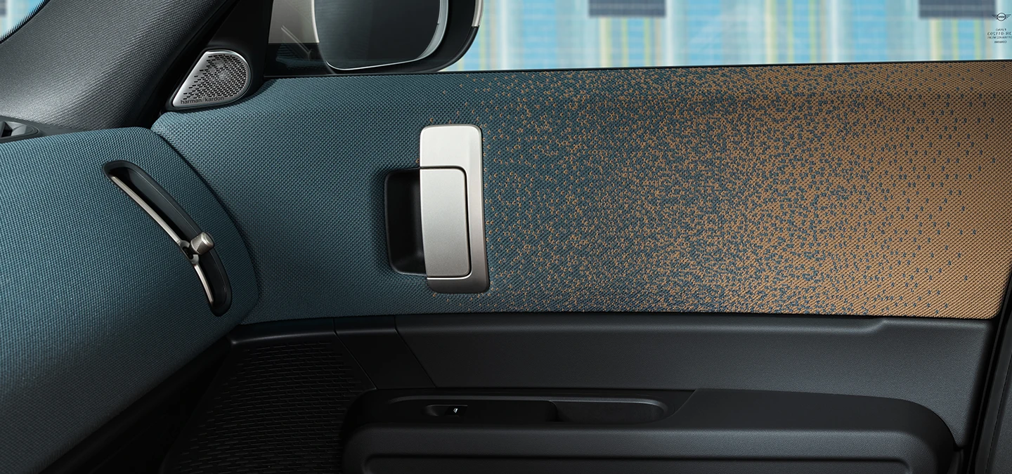 Close view of the interior design of the all-electric MINI Countryman with focus on the door and dashboard.